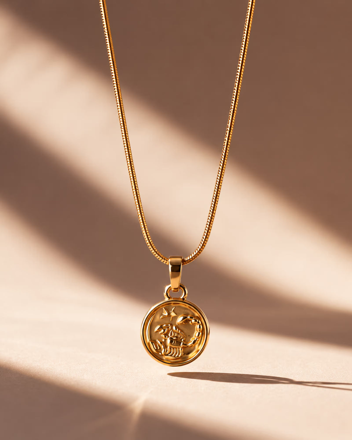Tie Shop Scorpio Necklace gold zodiac coin pendant display. سلاسل نسائية من تاى شوب سكوربيو نيكليس، قلادة ذهبية بدلاية دائرية لنقشة برج العقرب، مجوهرات وإكسسوارات أنيقة.