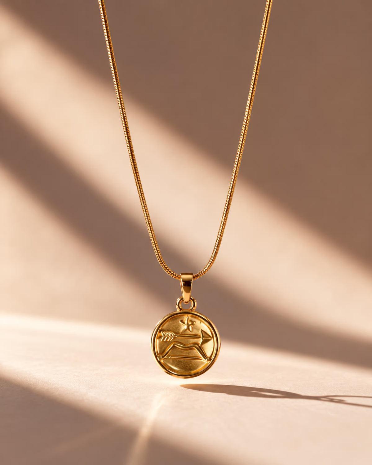 Tie Shop Sagittarius Necklace gold zodiac coin pendant display. سلاسل نسائية من تاى شوب ساجيتاريوس نيكليس، قلادة ذهبية بدلاية دائرية لنقشة برج القوس، مجوهرات وإكسسوارات أنيقة.