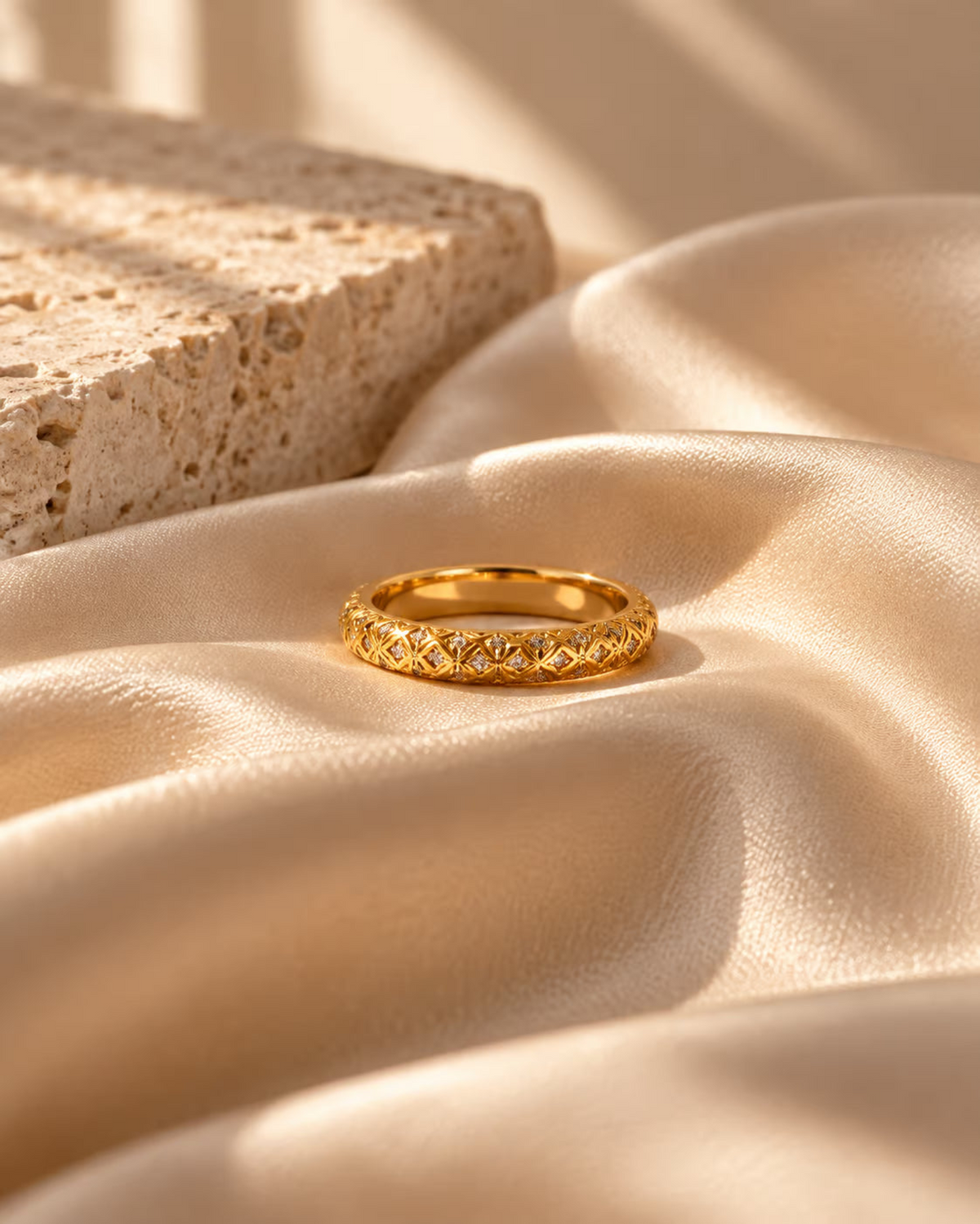Tie Shop Royal Rings gold quilted lattice band ring with cz crystals on silk background. خواتم نسائية من تاى شوب رويال رينجز، خاتم ذهبي بنقش شبكي محفور وفصوص زركون براقة، مجوهرات وإكسسوارات أنيقة.