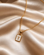 Tie Shop Y Initial Necklace gold mother of pearl pendant display. سلاسل نسائية من تاى شوب واي إنيشال نيكليس، قلادة ذهبية بدلاية مستطيلة بحرف Y وخلفية صدف عرق اللؤلؤ، مجوهرات وإكسسوارات أنيقة.