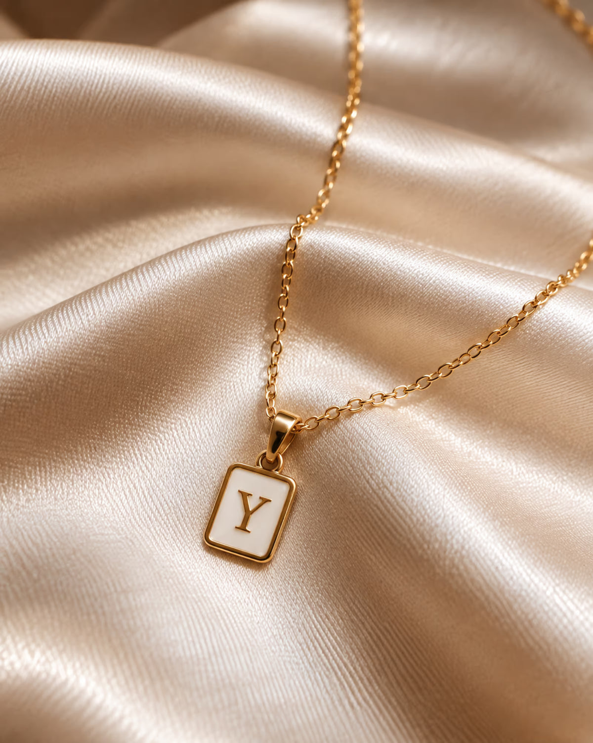 Tie Shop Y Initial Necklace gold mother of pearl pendant display. سلاسل نسائية من تاى شوب واي إنيشال نيكليس، قلادة ذهبية بدلاية مستطيلة بحرف Y وخلفية صدف عرق اللؤلؤ، مجوهرات وإكسسوارات أنيقة.