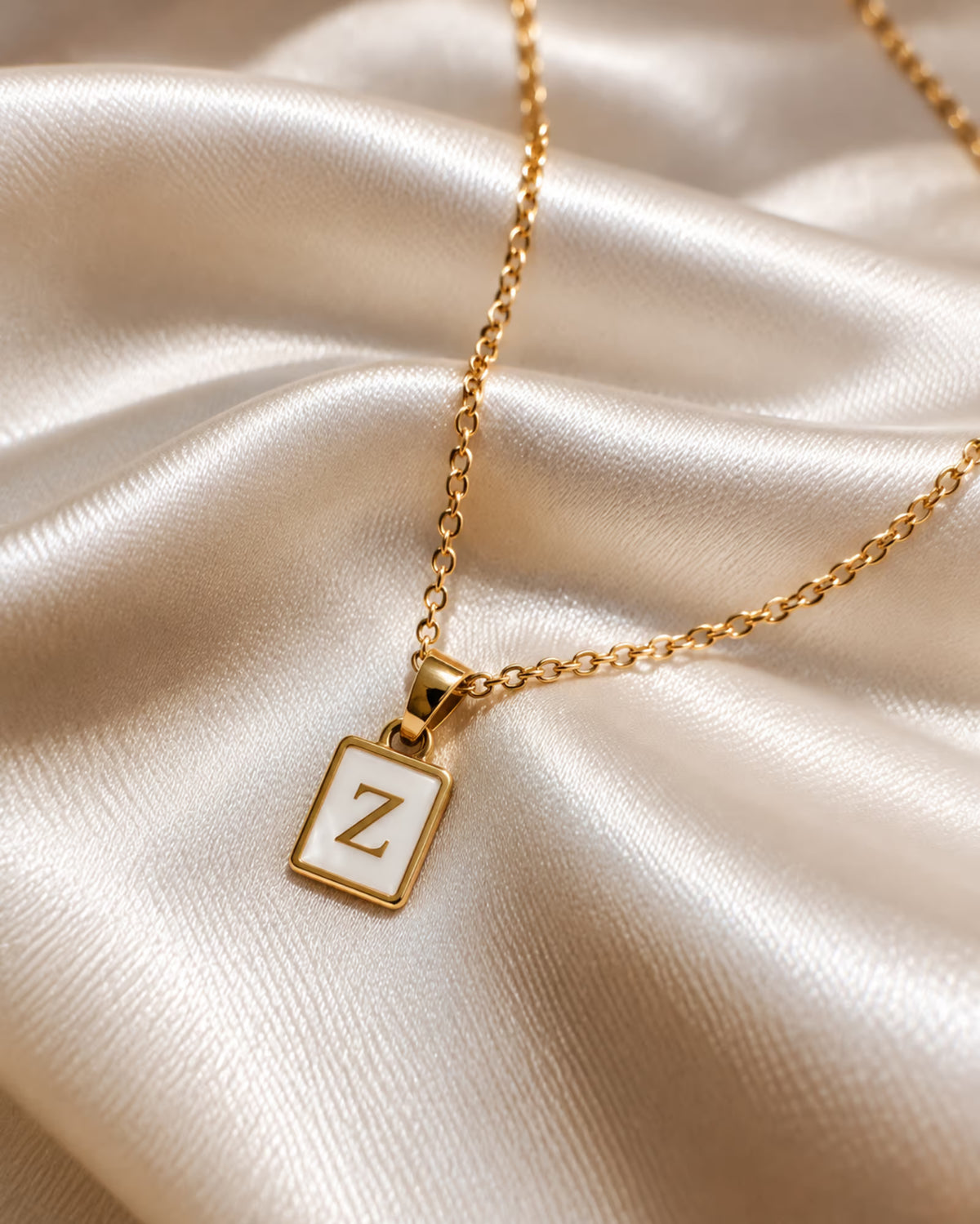 Tie Shop Z Initial Necklace gold mother of pearl pendant display. سلاسل نسائية من تاى شوب زد إنيشال نيكليس، قلادة ذهبية بدلاية مستطيلة بحرف Z وخلفية صدف عرق اللؤلؤ، مجوهرات وإكسسوارات أنيقة.