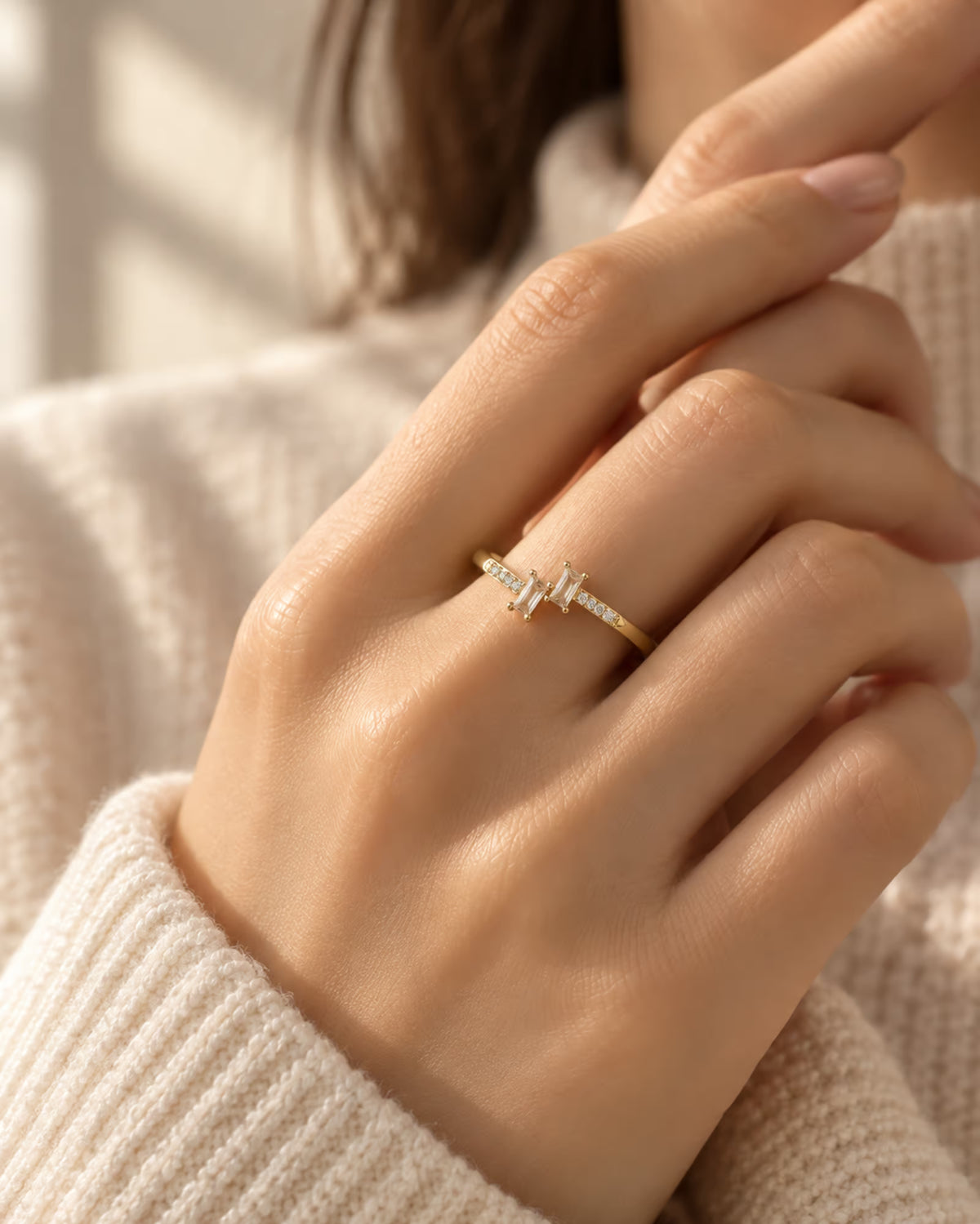 Tie Shop gold ring with double baguette cz stones on model hand. خواتم نسائية من تاي شوب خاتم ذهبي رفيع مرصع بحجرين مستطيلين من الزركون البراق، مجوهرات وإكسسوارات أنيقة.