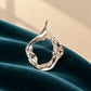 Detailed view of Tie Shop Abstract Fluid Silver Brooch, an elegant statement accessory for evening wear. عرض تفصيلي لـ بروش تجريدي انسيابي فضي من تاي شوب، اكسسوار أنيق يضفي لمسة راقية على إطلالات السهرة.