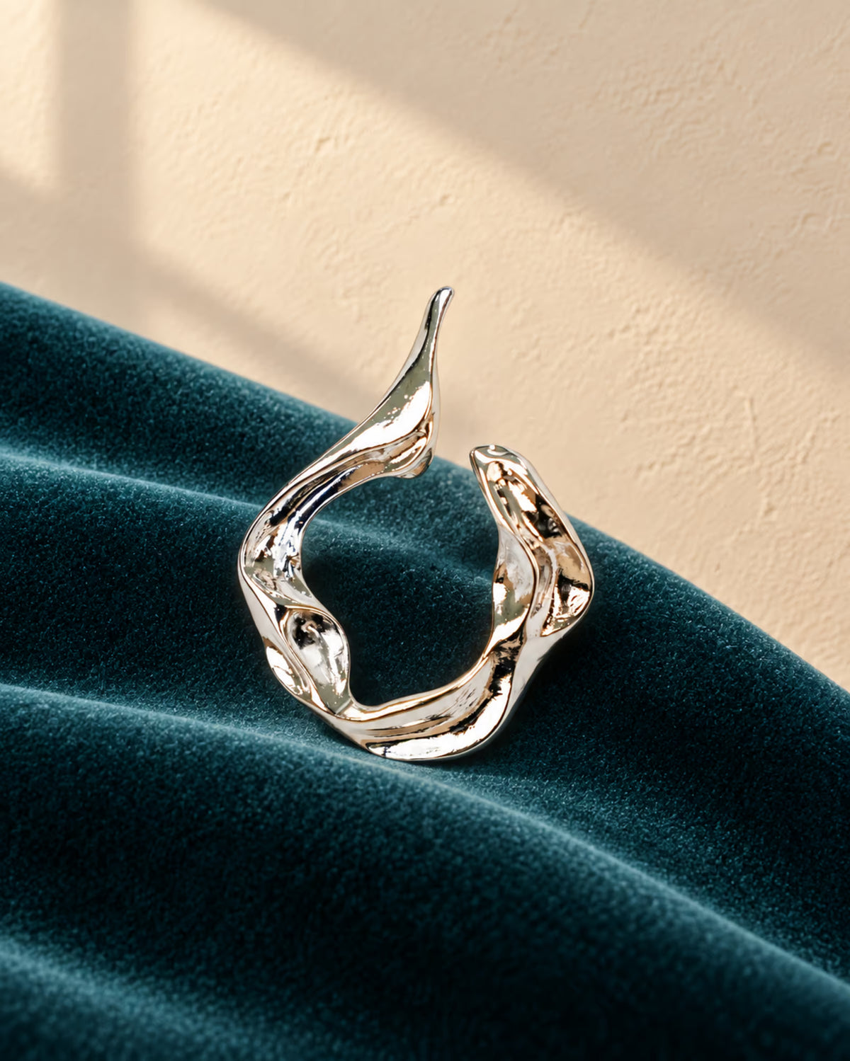 Detailed view of Tie Shop Abstract Fluid Silver Brooch, an elegant statement accessory for evening wear. عرض تفصيلي لـ بروش تجريدي انسيابي فضي من تاي شوب، اكسسوار أنيق يضفي لمسة راقية على إطلالات السهرة.