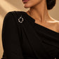 Model styling a black one-shoulder dress with the Abstract Fluid Silver Brooch from Tie Shop on the shoulder. موديل تنسق فستان أسود بكتف واحد مع بروش تجريدي انسيابي فضي من تاي شوب على الكتف.