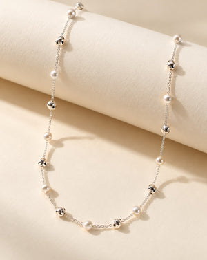 Tie Shop Pearl Station Chain silver necklace with alternating pearl and metallic beads display. سلاسل نسائية من تاى شوب بيرل ستيشن تشين، سلسلة فضية بتصميم محطات متناوبة من حبات اللؤلؤ والخرز الفضي البراق، مجوهرات وإكسسوارات أنيقة.