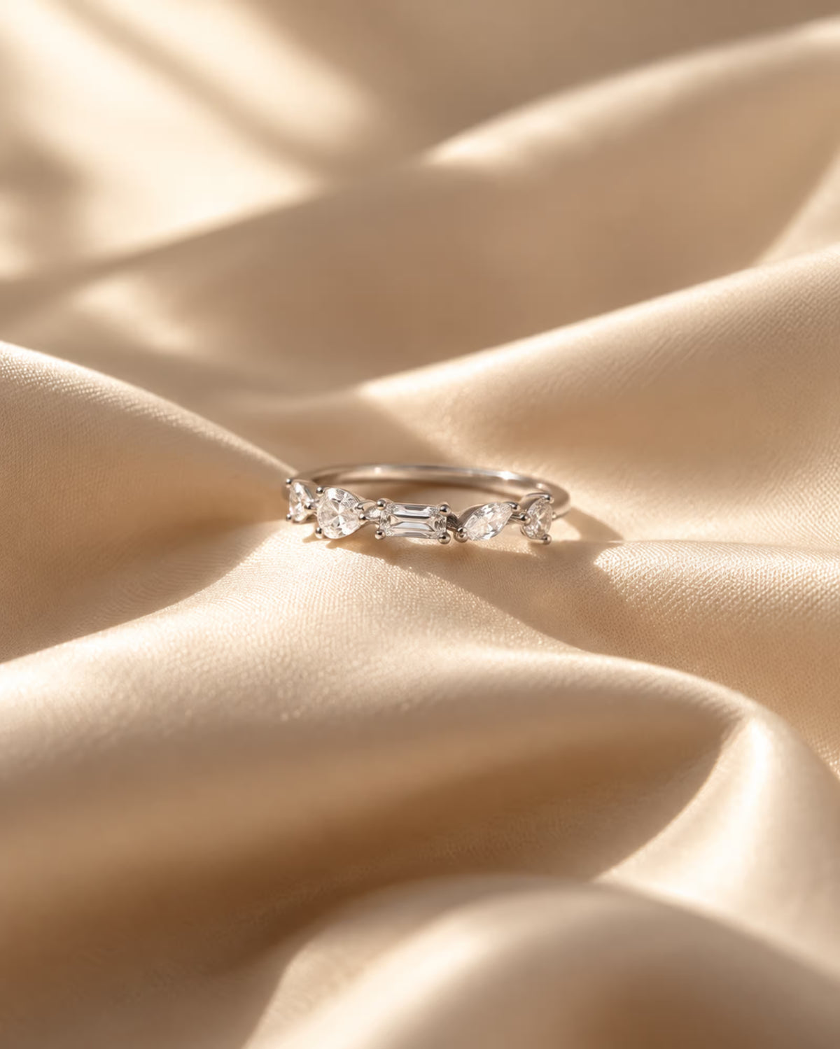 Tie Shop silver ring with multi-cut cz crystals on silk background. خواتم نسائية من تاي شوب خاتم فضي مرصع بأحجار الزركون بأشكال هندسية متنوعة، مجوهرات وإكسسوارات أنيقة.