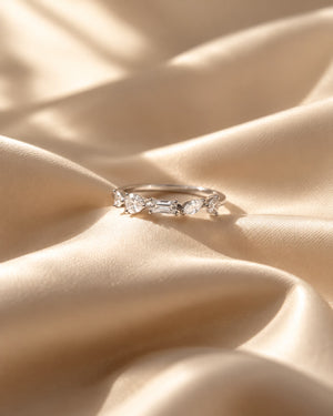 Tie Shop silver ring with multi-cut cz crystals on silk background. خواتم نسائية من تاي شوب خاتم فضي مرصع بأحجار الزركون بأشكال هندسية متنوعة، مجوهرات وإكسسوارات أنيقة.