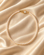 Tie Shop Classic Pearl Necklace beaded pearl choker with gold floral toggle clasp display. سلاسل نسائية من تاى شوب كلاسيك بيرل نيكليس، عقد من اللؤلؤ الكلاسيكي بقفل ذهبي أنيق، مجوهرات وإكسسوارات أنيقة.