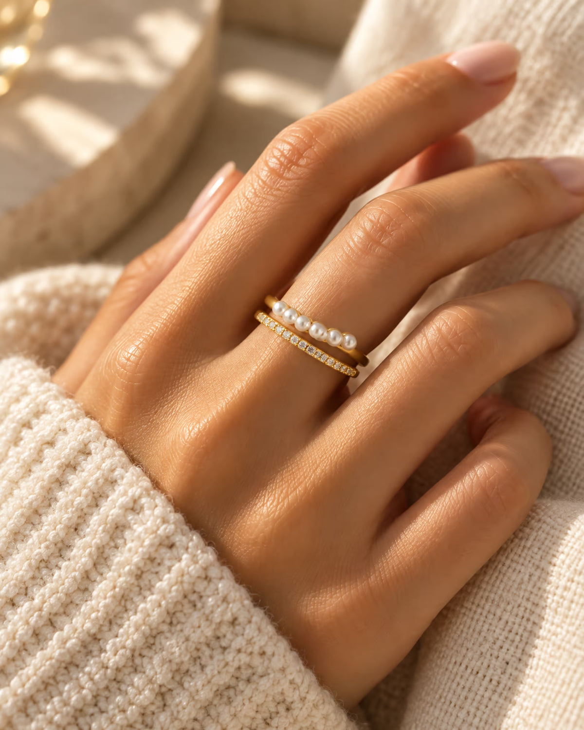 Tie Shop gold double band ring with pearls and cz crystals on model hand. خواتم نسائية من تاي شوب خاتم ذهبي مزدوج مرصع باللؤلؤ وأحجار الزركون، مجوهرات وإكسسوارات أنيقة.