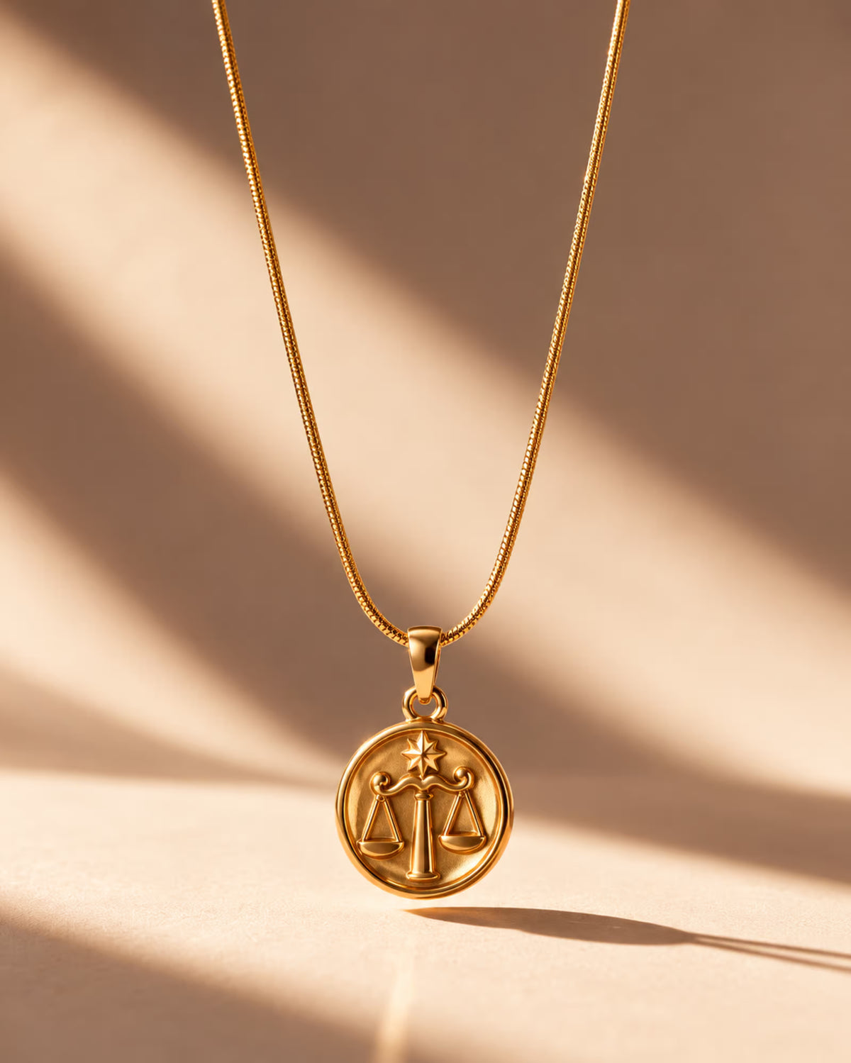 Tie Shop Libra Necklace gold zodiac coin pendant display. سلاسل نسائية من تاى شوب ليبرا نيكليس، قلادة ذهبية بدلاية دائرية لنقشة برج الميزان، مجوهرات وإكسسوارات أنيقة.