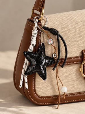 Tie Shop Black Snake Texture Star Bag Charm. تعليقة شنطة نسائية من تاي شوب بنجمة سوداء مزخرفة وأشرطة محبوكة، إكسسوار أنيق للحقائب.