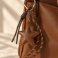 Tie Shop Brown Leather Star Bag Charm on leather tote. تعليقة حقيبة نسائية من تاي شوب بنجمة جلدية بنية، إكسسوار أنيق للشنط والميداليات.