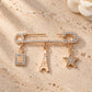Zia Paris Charm Pin women brooch by Tie Shop. بروش ذهبي مرصع بالكريستال بتصميم عصري راقي.