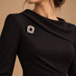 Tie Shop Silver Interwoven Knot Brooch on black dress. بروش نسائي من تاي شوب بتصميم فضي حلزوني متداخل، إكسسوار أنيق للحجاب والملابس.