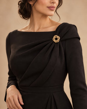 Tie Shop Gold Interlocking Curved Ring Brooch on black dress. بروش نسائي من تاي شوب بتصميم دوائر ذهبية متداخلة محززة، إكسسوار أنيق للحجاب والملابس.