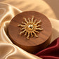 Tie Shop Gold Sunburst Brooch on wooden stand with satin fabric. بروش نسائي من تاي شوب بأشعة شمس ذهبية بارزة، إكسسوار أنيق للحجاب والملابس.
