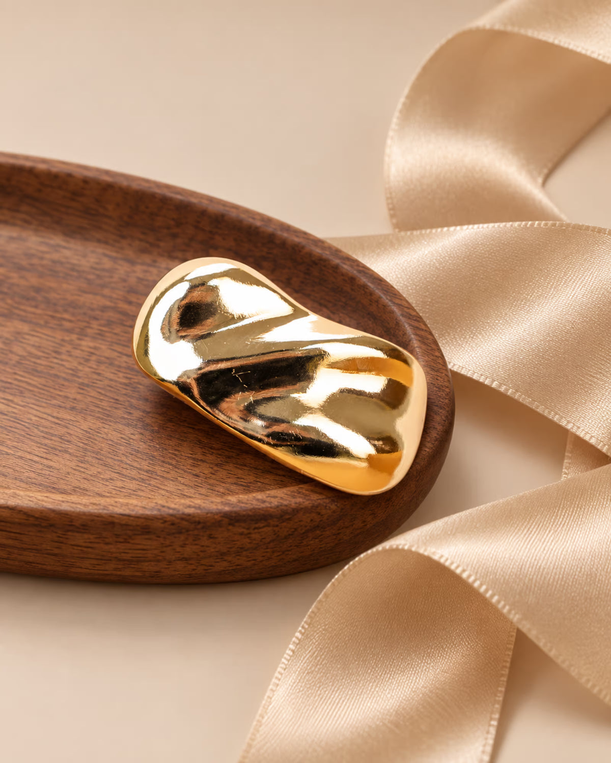 Close-up of Tie Shop Gold Wave Bar Brooch with ribbon. بروش نسائي من تاي شوب عصري باللون الذهبي، إكسسوار أنيق للحجاب والملابس.