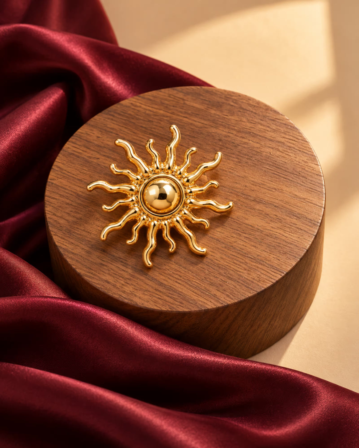 Close-up of Tie Shop Gold Sunburst Brooch on wooden pedestal. بروش نسائي من تاي شوب بتصميم شمس مصقولة، إكسسوار أنيق للحجاب والملابس.