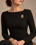 Tie Shop Gold Hammered Oval Brooch on black dress. بروش نسائي من تاي شوب بتصميم بيضاوي ذهبي مطروق، إكسسوار أنيق للحجاب والملابس.