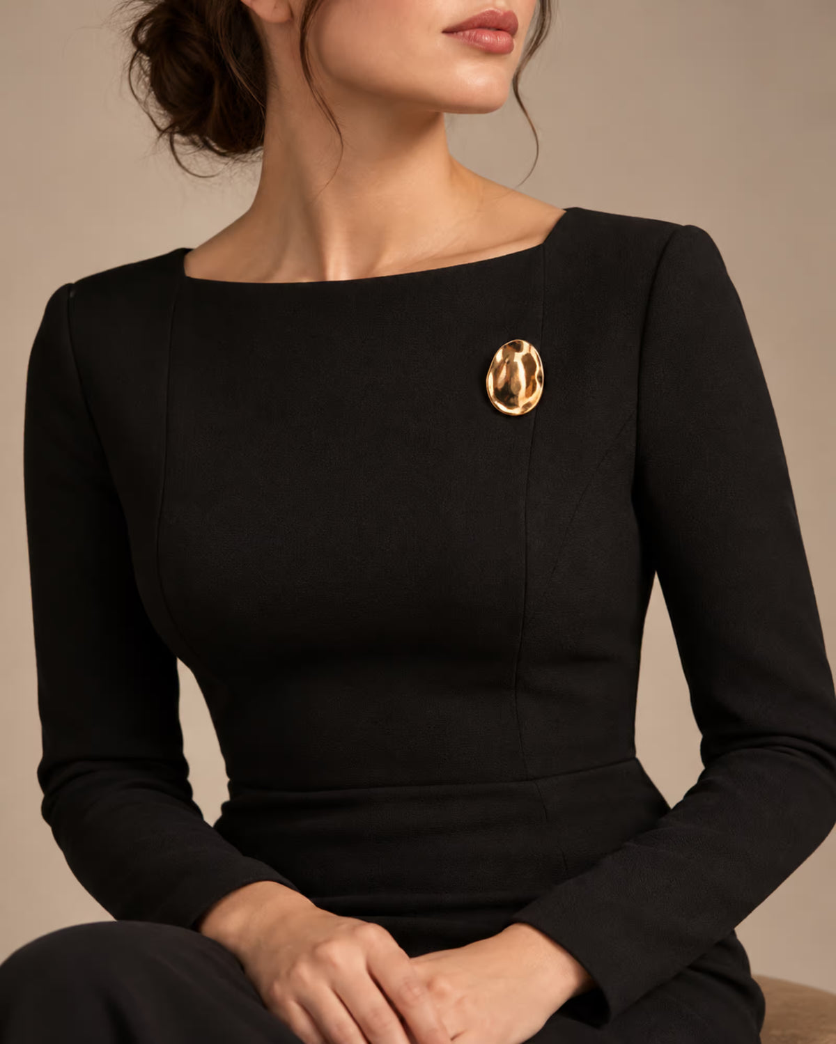 Tie Shop Gold Hammered Oval Brooch on black dress. بروش نسائي من تاي شوب بتصميم بيضاوي ذهبي مطروق، إكسسوار أنيق للحجاب والملابس.