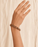 Tie Shop Stylish Bracelet gold geometric chain link design on model wrist. أساور نسائية من تاي شوب ستايلش براسليت بتصميم سلسلة ذهبية هندسية متداخلة، مجوهرات وإكسسوارات أنيقة.