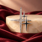 Close-up of Tie Shop Silver Sparkling Star Crystal Brooch on a marble pedestal with burgundy satin background, a premium fashion pin. صورة مقربة لـ بروش النجوم الفضي المرصع بالكريستال من تاي شوب على قاعدة رخامية وقماش نبيتي فاخر. بروش Zia لإطلالة أنيقة مع الحجاب