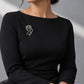 Model wearing an elegant black formal dress styled with Tie Shop Silver Abstract Line Art Face Brooch on the chest, a modern artistic accessory. موديل ترتدي فستان أسود أنيق مزين بـ بروش وجه المرأة الفني الفضي من تاي شوب على الصدر، لمسة فنية معاصرة للملابس. نسّقي إطلالتك مع بروش تاى شوب الأنيق