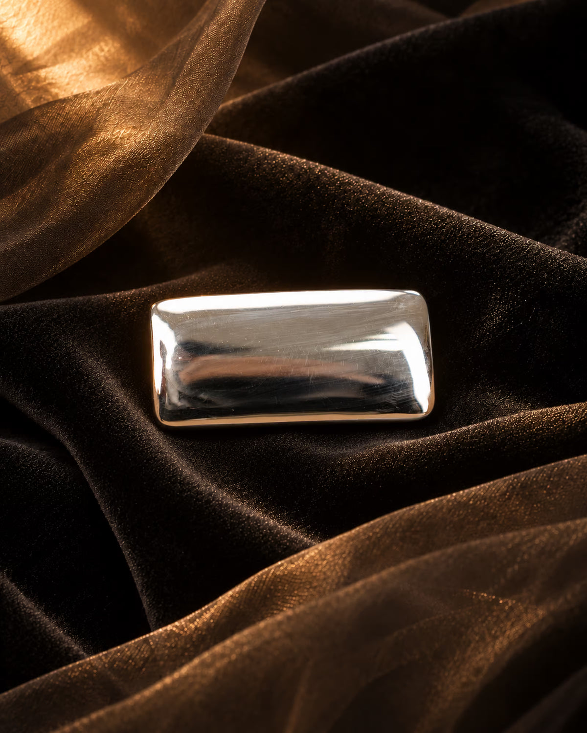 Close-up of Tie Shop Minimalist Silver Rectangular Brooch with smooth polished finish, a sleek metallic accessory for abayas, suits, and hijabs. صورة مقربة لـ بروش فضي مستطيل بتصميم مينيماليست ناعم من تاي شوب، اكسسوار معدني عصري للعبايات والبدلات والحجاب.