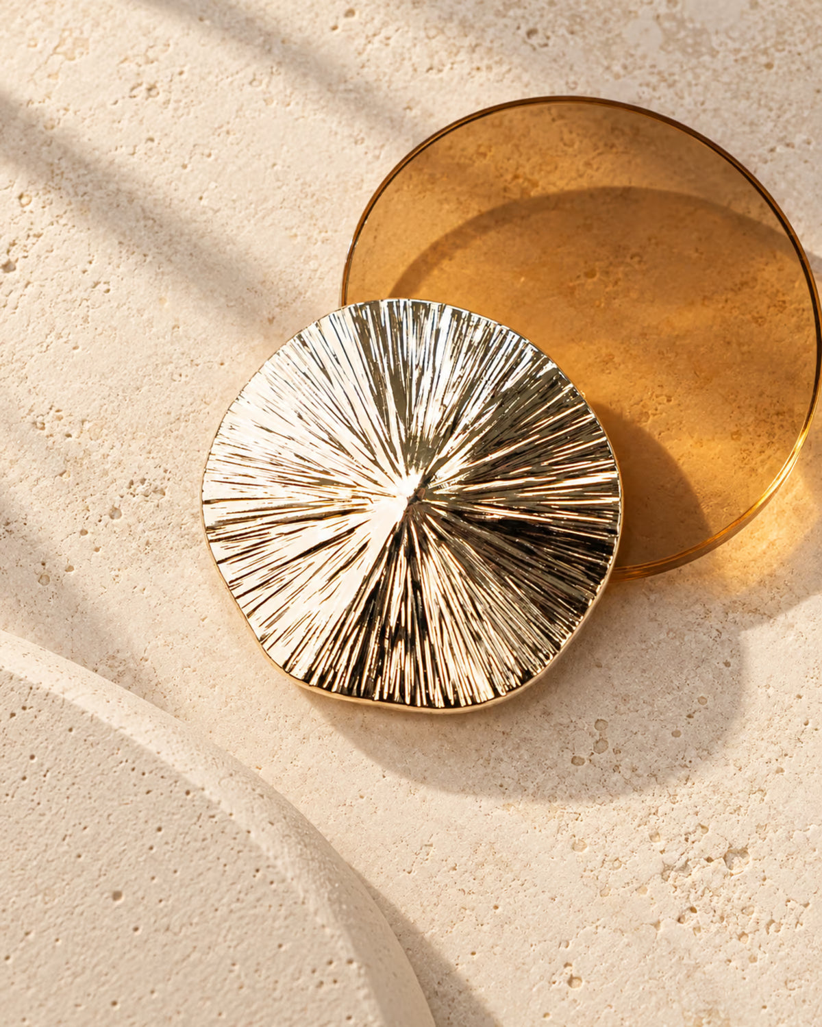 Close-up of Tie Shop Textured Sunburst Round Gold Brooch, a luxury metallic accessory designed for abayas, dresses, and hijabs. صورة مقربة لـ بروش ذهبي دائري بتصميم شعاعي من تاي شوب، اكسسوار معدني فاخر للعبايات والفساتين والحجاب.