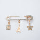 Zia Paris Charm Pin brooch by Tie Shop. بروش دبوس نسائي ذهبي بدلايات برج إيفل، زجاجة عطر، ونجمة مرصعة بالكريستال.